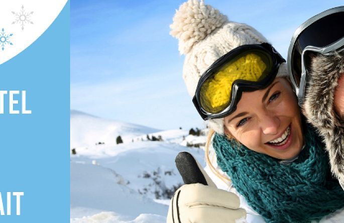 Un homme et une femme dans la neige avec une tombola pour 2 nuits d'hôtel pour 2 jours de forfait de ski