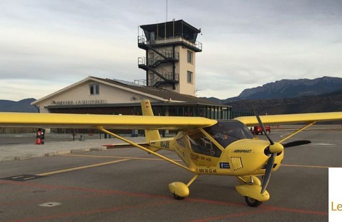 un petit avió groc està estacionat a la pista de l'aeroport