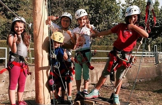 un groupe d'enfants portant des casques et des harnais levant les pouces