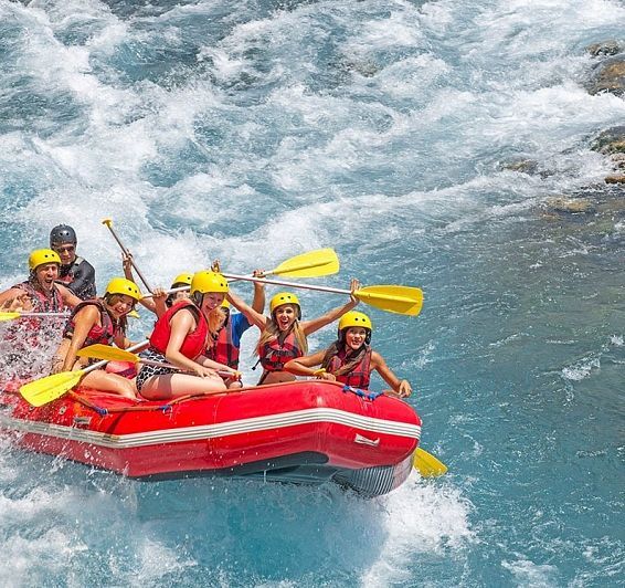 un grupo de personas están remando en un bote rojo en un río